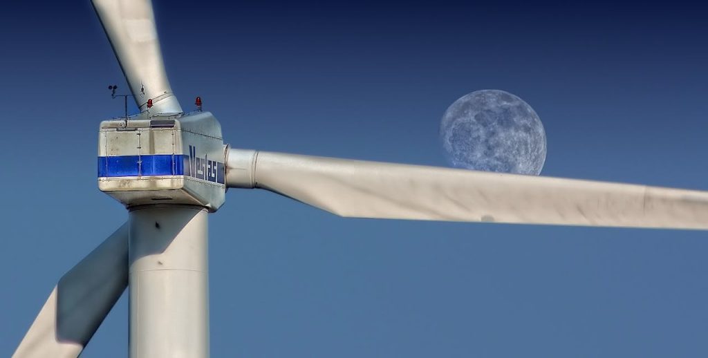 Wind turbine blades with moon backdrop, highlighting renewable energy aesthetics.